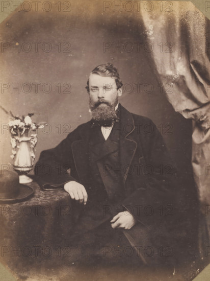 Portrait of an unknown man, standing with a stick in his hand, photograph, photographer: attributed to Franz Hanfstaengl, Germany, c. 1855 - c. 1860, Attributed to, paper, salted paper print, salt print, height 214 mm x width 171 mm, height 240 mm x width 196 mm, A sepia portrait of a seated man with a full beard and mustache wearing a dark three-piece suit and a bow tie, his hair combed back and a serious facial expression; his right arm rests on a patterned tablecloth where a round hat and an ornate vase with flowers are placed, and a draped curtain hangs to the right of the frame.