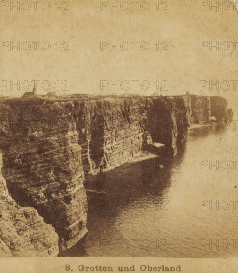 View of the cliffs of Helgoland, Germany, Helgoland : Grotten und Oberland, Views and landscapes in Europe, Africa and Asia, Geographical Sculpture Gallery, collected by MJ Broekhuijsen, Head of a school in Amsterdam, stereograph, Numbered 8. in the lower right corner of the photo, annotation: 'A steep coast. The west side of Helgoland (cf. plate 23) from, viewed from the NW.', publisher: Merkelbach & Co., Amsterdam, compiler (person in literature): Martien Johan Broekhuijsen, c. 1905, photographer, compiler (person in literature), pasteboard, paper, albumen print, height 89 mm x width 178 mm, Part of a group of 52 stereophotos used in primary education as a supplement to school charts. The entire series consisted of 274 items in 10 categories (A to K)., coastal cliff or crag, A sepia-toned photograph showing a high, rocky cliff face extending along a coastline with striated rock layers and vertical fissures, the cliff edge running horizontally near the top where small buildings and a ...
