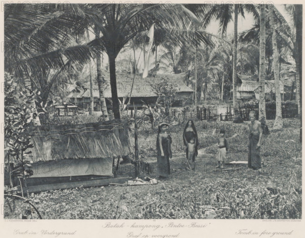 Inhabitants of Batak village 'Pintoe-Bessi' on Sumatra, with a grave in the foreground, Batak - kampong „Pintoe - Bessi' Grave in foreground, photomechanical print, Part of Album with heliogravures of Sumatra's east coast., number: '49', photographer: Carl J. Kleingrothe, Sumatra, clichémaker: Johann Baptist Obernetter, Munich, in or before 1898, Bavaria, paper, photoaquatint, heliogravure, height 207 mm x width 287 mm, grave, tomb, village, A monochrome scene shows tall palm trees with large fronds towering over a village clearing containing thatched huts and woven fences; in the foreground there is a low structure with a frayed thatch roof and scattered vegetation, and a group of people standing on the bare ground including women and children wearing simple cloth garments and a man wrapped in a cloth, all surrounded by dense tropical foliage and more traditional houses in the background.