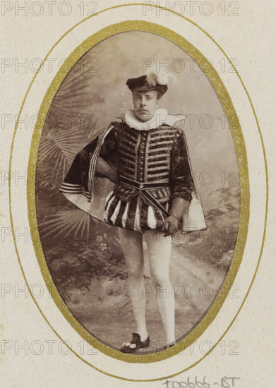 Portrait of Johannes Pieter Stephan Gualthérie van Weezel in costume, album page, photograph, carte-de-visite, This photo is part of an album., inscription: 'Ant. J. van der Stok, Leiden Rapenburg 13.', name: 'JPS Gualtherie v. Weezel., 106.', photographer: Antonius Joannes van der Stok, Leiden, 1887-01-01 - 1899-12-03, paper, pasteboard, albumen print, albumendruk, height 83 mm x width 52 mm, Person, Johannes Pieter Stephan Gualthérie van Weezel, historical persons, historical costume, An oval vintage photograph shows a person standing in theatrical attire framed by a textured mat with concentric gold rings; the person wears a dark hat with a white plume, a high ruffled collar, a patterned jacket with horizontal decorative bands and buttons, a cape draped over one shoulder with striped trim, a short skirt-like garment with alternating light and dark vertical panels, light-colored tights, and dark shoes with decorative elements; one hand rests on the hip while the other holds a small p...