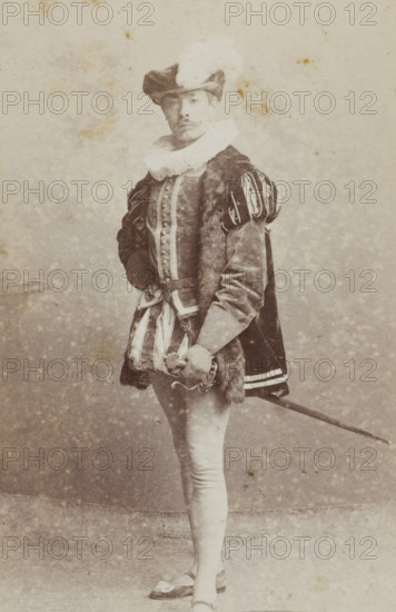 Portrait of a young man in costume with a sword, identified as NA de Joncheere, album page, photograph, carte-de-visite, This photo is part of an album., inscription: 'J. Goedeljee, Photographer, HRH PRINCE ALEXANDER, of the Netherlands, PRINCE of ORANGE, and HRH PRINCESS HENDRIK, Hoogewoerd 160, near the Plantage.', name: 'NA de Joncheere., 207.', photographer: Jan Goedeljee, Leiden, 1860 - 1905, paper, pasteboard, albumen print, height 83 mm x width 52 mm, historical persons, historical costume, hacking and thrusting weapons: rapier, A sepia-toned portrait of a person standing and facing forward, wearing a broad-brimmed hat with a turned-up side and a feather, a large ruffled collar, a fitted doublet with decorative buttons down the front, padded and slashed sleeves, a fur-trimmed cloak draped over one shoulder, striped short breeches over tight hose, flat shoes with decorative bows, and holding a sword at their side with one hand resting on the hilt.