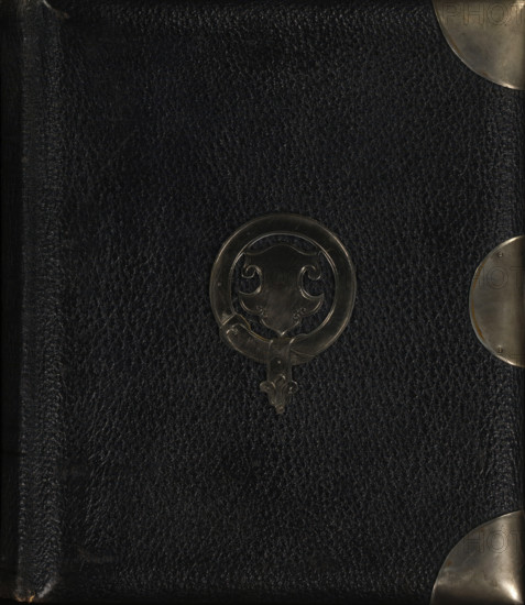 Photo album (empty), photograph album, slip-in album, Photo album with forty pages, each with a passe-partout framed with gold lines for a cabinet photo., collector's mark: 'DIENST, VERSPREIDE, RIJKSKOLLEKTIES, A 837', 1860 - 1900, pasteboard, biological material, inorganic material, paper, leather, metal, color on edges, cardboard slip-in album, covered with black leather with a metal ornament of a coat of arms in a circle on the front cover, four metal corners, metal clasp and clasp holder, decorative border printed in gold along the inside of the boards, endpapers of iridescent paper, cardboard sheets with gold edges, height 234 mm x width 205 mm x thickness 55 mm x width 399 mm, A close view of a dark textured surface with a pebbled leather appearance, featuring a circular metal ornament with an ornate shield-like design near the center and curved metallic corner protectors visible along the right edge and top right corner, the metal pieces showing a slightly worn and brushed finis...