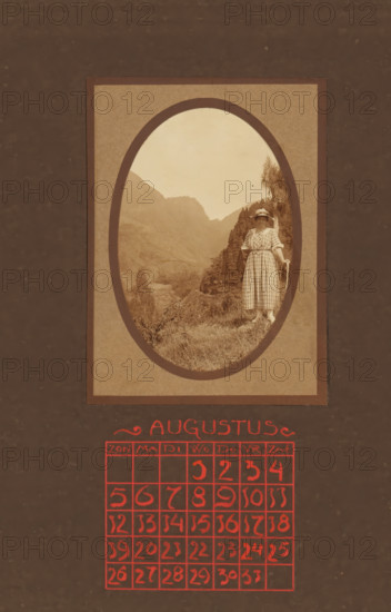 Landscape with mountains, with a female traveler with a hat in the foreground, album page, photograph, This photo is part of an album., annotation: 'AUGUSTUS, ', Indonesia, 1880 - in or before 1923, photographer, pasteboard, paper, daylight collodion silver print, height 98 mm x width 65 mm, adult woman, travelling, tourism, mountains, A sepia-toned photograph framed in an oval mat shows a woman standing on a grassy hillside with a mountainous valley behind her; she wears a checked dress with a belt at the waist and a wide-brimmed hat, and she rests one hand on a walking stick while the other hangs by her side, with trees and shrubs visible on the slope near her and layered hills rising into the hazy sky; below the framed photo a decorative heading in stylized red lettering appears above a grid of red hand-drawn squares containing red handwritten numerals.