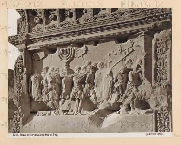 Rome Bas-relief of the Arch of Tito, Bas-relief on the Arch of Titus in Rome, depicting objects taken from the Temple of Jerusalem as booty of war, photograph, Part of Photo album with photographs of sights and artworks in Italy., number: '4213', photographer: Edizioni Brogi, Rome, c. 1875 - in or before 1907, paper, gelatin silver print, height 197 mm x width 250 mm, booty, spoil, sculpture (relief, sculpture), Emperor Titus destroying the temple of Jerusalem, A close-up photograph of a carved stone relief showing a procession of robed figures in profile, some carrying a multi-branched ceremonial object on a pedestal and others bearing long poles and rectangular standards, all rendered in worn, light-colored stone with detailed drapery and facial features; the relief is set within an ornate architectural frame with floral and geometric carvings along the top and sides, a horizontal cornice with layered moldings above the scene, and sculpted decorative panels flanking the figures, with...