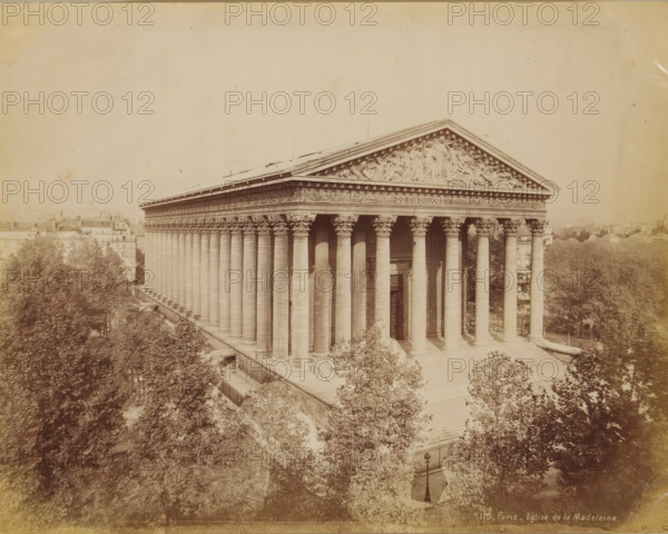 La Madeleine in Paris, album page, photograph, This photo is part of an album., inscription: '115, Paris_ Eglise de la Madeleine', photographer: anonymous, 1880 - 1900, paper, autotype, height 216 mm x width 275 mm, trees, church (exterior), Paris, Madeleine, A sepia-toned photograph of a classical building with a wide portico supported by tall fluted columns topped with ornate capitals, a triangular pediment decorated with sculpted figures, a broad flight of steps leading up to the entrance, trees surrounding the building at the foreground and flanking both sides, rooftops and distant buildings visible beyond the left side, and a lamppost near the bottom center of the image.