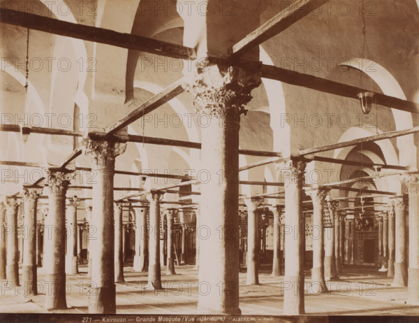 Kairouan, Grande Mosquée (vue intérieure), Courtyard of the Great Mosque of Kairouan, photograph, number: '271', photographer: Albert Goupil, 1860 - 1900, North Africa, pasteboard, paper, albumen print, height 247 mm x width 317 mm, temple, shrine, Islam, Mohammedanism, Great Mosque of Kairouan, The image shows rows of tall columns with carved capitals supporting horizontal beams and a series of rounded arches in a large, open interior space, with hanging light fixtures suspended from some beams and patterned bases at the foot of several columns.