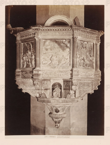 Pulpit after Benedetto da Maiano in the Santa Croce in Florence, Italy, Pulpito in S. Groce di Benedetto da Majano, Firenze, photograph, number: '3141.', address: 'GIACOMO BROGI, FOTOGRAFO-EDITORE, FIRENZE, LUNG ARNO DELLE GRAZIE 15', photographer: Giacomo Brogi, Florence, publisher: Edizioni Brogi, after sculpture by Benedetto da Maiano, 1864 - 1881, Benedetto da Maiano, after sculpture by, Tuscany, pasteboard, paper, albumen print, albumendruk, height 470 mm x width 350 mm, pulpit, ambo, chancel, Santa Croce, An ornate stone pulpit with carved panels and columns sits against a wall, featuring a central rectangular relief depicting figures and a landscape above a seated sculpted figure in a niche, flanked by two side reliefs showing groups of standing and seated figures within architectural settings, all topped by an elaborately decorated cornice with floral and geometric motifs and supported by a carved bracket with scrollwork and a textured pendant.