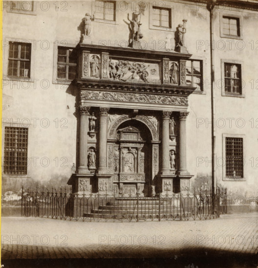 Portail de Sainte-Sophie, à Dresde., Portal der Sophienkirche, in Dresden, Portal of the Sophienkirche in Dresden, Saxe., Sachsen, stereograph, number: 'No. 430.', number: '430', photographer: Athanase Clouzard (possibly), Dresden, 1860 - 1879, Saxony, pasteboard, paper, albumen print, albumendruk, height 88 mm x width 175 mm, parts of church exterior and annexes: portal, Sophienkirche (Dresden), A sepia-toned photograph of a building facade showing a richly carved stone doorway with an ornate arch and decorative panels flanked by fluted columns and sculpted figures on pedestals, a horizontal frieze with reliefs above the doorway, and additional statues on the roofline. The wall around the entrance features rectangular windows with divided panes at various heights, some with bars, and a vertical downpipe running beside one window. In front of the entrance a low set of steps leads up to the doorway and a metal fence with pointed finials encloses the area. The ground in front of the fenc...