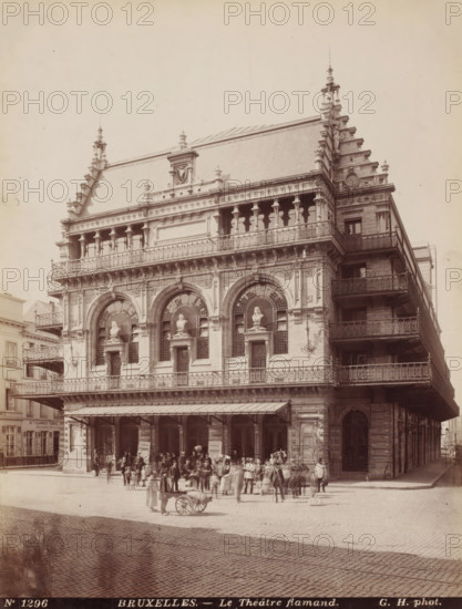 View of the Royal Flemish Theatre in Brussels, Belgium, Le théâtre flamand, Bruxelles, photograph, number: 'No 1296', photographer: Gustave Hermans, Brussels, 1884 - 1914, paper, albumen print, height 284 mm x width 216 mm, theatre (building), Royal Flemish Theatre, A large ornate stone building with a steep tiled roof and decorative pinnacles occupies most of the image, its façade featuring a row of arched openings with sculpted busts set in recessed niches, an upper balcony with balustrade and a colonnaded loggia, and multiple tiers of wrought iron balconies along the right side; people and small groups stand and walk on the paved area in front of the building, some clustered near the entrance while others push a small handcart, and a covered awning projects above the ground floor arcade.