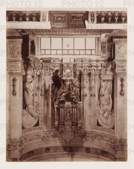 Altare d'Argento (del duomo), Altar in the cathedral in Pisa, Italy, Pisa, photograph, number: '3452.', 1851 - 1900, photographer, Tuscany, pasteboard, paper, albumen print, albumendruk, height 384 mm x width 307 mm, altar, Cathedral (Pisa), An ornate interior view showing a richly carved altar area with vertical columns and decorative pilasters, an elaborate central sculptural canopy with detailed relief work, and a suspended ornamental lantern or canopy piece; sculpted figures are set into niches on either side, each draped in flowing robes and positioned within rounded shell-like alcoves; the upper section features a framed rectangular panel with decorative molding and a patterned cornice, while the surrounding stonework includes carved medallions, floral motifs, and acanthus detailing; balustrades and carved panels run along the top edge and the lower arch displays patterned friezes and round medallion insets.