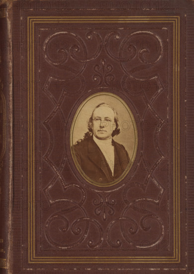Portrait of Johannes Petrus Hasebroek, photograph, c. 1869 - in or before 1874, photographer, paper, albumen print, albumendruk, height 67 mm x width 48 mm, Photo on outside front cover., Person, Johannes Petrus Hasebroek, picture, painting, A worn brown book cover with embossed decorative scrollwork and a rectangular border of thin gold lines surrounding an oval inset photograph of a middle-aged person with light-colored hair, wearing a dark coat and a light shirt, the oval photograph framed by a thin gold rim and positioned near the center of the cover.
