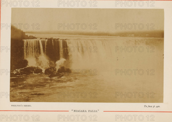 Niagara Falls, View of Niagara Falls, photograph, page, inscription: 'POULTON'S SERIES., To face p.440.', photographer: Poulton, Niagara Falls (North America), c. 1870 - c. 1890, Poulton, photographer, North America, paper, albumen print, height 88 mm x width 143 mm, waterfall, A sepia-toned photograph of a wide waterfall seen from an elevated vantage showing water cascading over a high cliff into a misty plunge below, with vertical streams of water separated by darker rock faces, turbulent water and scattered boulders at the base, a broad placid river above the falls stretching toward a distant hazy shoreline, a tree-covered landmass at one side, and a pale border surrounding the image.