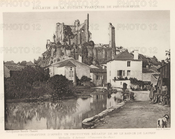 Château de Chantilly, seen from the garden side, Chateau de Chantilly (Coté des Jardins), page, photomechanical print, photographer: H. Rouxel, Chantilly, cliché maker: Jules Royer, Nancy, c. 1886 - in or before 1891, printer (person), paper, collotype, photoprint, height 120 mm x width 171 mm, Print on unnumbered page., castle, A riverside scene shows a stone embankment and a calm reflective body of water in the foreground with buildings and vegetation along the far bank, including a pale multi-story house with shuttered windows and a doorway opening onto the water. Behind these houses a large ruined stone structure with tall battered walls and towers rises on a rocky hill. Trees and shrubs grow among the buildings and ruins. On the right a narrow dirt path runs beside the water where a woman in a long dress and a man in simple clothing stand near a wooden cart, and two dogs walk along the path toward the foreground. The sky above is clear and pale.
