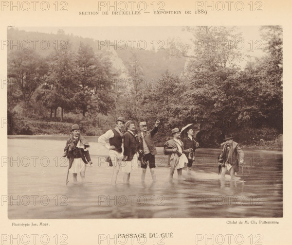 Passage du Gué, Group of men in the river Lesse, page, photomechanical print, inscription: 'Section de Bruxelles - Exposition de 1889', photographer: Charles Puttemans, Lesse, cliché maker: Joseph Maes, Antwerp, c. 1883 - in or before 1888, printer (person), Maas, paper, collotype, photoprint, height 115 mm x width 164 mm, Print on unnumbered page., adult man, crossing a river, A sepia photograph shows a group of men standing waist-deep in a body of water near a wooded shoreline, wearing period clothing including jackets, hats, and walking sticks; some men hold umbrellas or bags, one man points outward while others look in various directions, and trees and a hillside form the background.