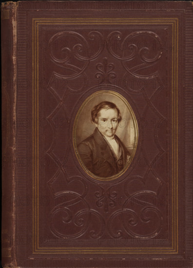 Photo reproduction of an engraving of a portrait of Johannes Petrus Hasebroek, photograph, reproduction, page, after print by anonymous, c. 1869 - in or before 1874, photographer, after print by, paper, albumen print, height 67 mm x width 49 mm, Photo on front cover., Person, Johannes Petrus Hasebroek, historical persons, A worn dark brown book cover with embossed scrolling decorative patterns and several narrow parallel border lines in a lighter brown or gold tone, featuring an oval portrait inset near the center showing a seated man with short hair wearing a dark coat and light-colored shirt, the portrait framed by a thin metallic-looking oval border.