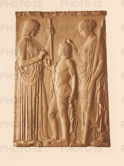Relief with Demeter, Tripolemos and Persephone, Relief d'Eleusis: Déméter, Triptolémos, Coré, page, photomechanical print, photographer: Frédéric Boissonnas, Greece, cliché maker: Meisenbach, Riffarth & Cie., Berlin, c. 1905 - in or before 1910, Frédéric Boissonnas, Meisenbach, photographer, cliché maker, paper, photoaquatint, height 290 mm x width 208 mm, Photo on page 88., sculpture, Euboea, Attica, Elefsina, A rectangular stone relief depicting three standing figures carved in shallow bas-relief, all rendered in a warm sepia tone; a central youthful nude figure faces left with wavy hair and a contrapposto stance, flanked on the left by a robed figure with draped garments holding a tall staff and touching the central figure, and on the right by another robed figure with hair pulled back and a draped cloak holding a staff and reaching toward the central figure; the surface shows carved folds of fabric, textured hair, and feet at the base, with a narrow border along the top and bottom ...
