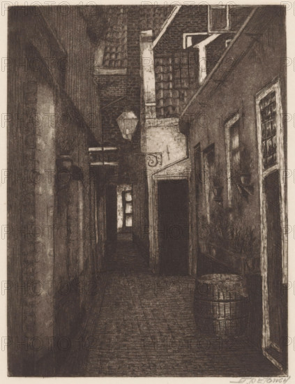 Alley at evening, print, In the alley a wooden barrel., inscription: 'S. de Jongh Twijnstraat 43 bis A Utrecht', printmaker: S. de Jongh (signed by artist), in or before 1935, paper, etching, intaglio printmaking technique, height 173 mm x width 133 mm, lane, alley, evening, A narrow, dim alleyway rendered in dark, fine lines with textured walls and a cobbled floor, flanked by tall buildings with visible window frames and doorways; a barrel sits near a doorway on the right beside a planter box filled with foliage, and small wall-mounted shelves hold pots; overhead, a hanging lantern is suspended between the buildings beneath a sloped roof with visible tiles and chimneys, while farther down the passage a small window emits a brighter rectangular area of light.