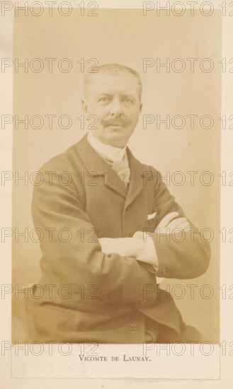 Vicomte De Launay, Portrait of Alphonse de Launay, photograph, page, c. 1881 - in or before 1891, photographer, paper, albumen print, height 153 mm x width 95 mm, Photo opposite title page., Person, Alphonse de Launay, portrait, self-portrait of artist, A sepia portrait of a man seated with arms crossed, wearing a dark suit jacket, a patterned necktie, and a white shirt with visible cuffs, showing a neatly trimmed moustache and short hair, set against a plain light background.