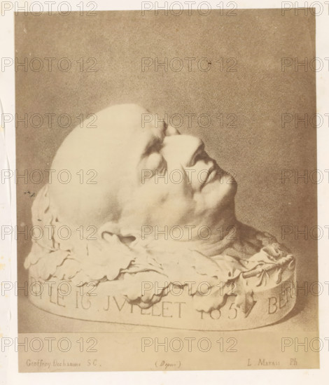Photo reproduction of a drawing depicting a plaster cast of the death mask of Pierre-Jean de Béranger, photograph, reproduction, page, photographer: L. Marais, after drawing by anonymous, c. 1858 - in or before 1868, paper, albumen print, height 144 mm x width 120 mm, Person, Pierre-Jean de Béranger, death-mask, A sepia-toned photograph showing a sculpted head turned upward with closed eyes and relaxed facial features, the smooth rounded skull and defined nose and lips visible, resting on a carved base adorned with layered, draped cloth-like forms and ornate folds, all set against a textured neutral background.