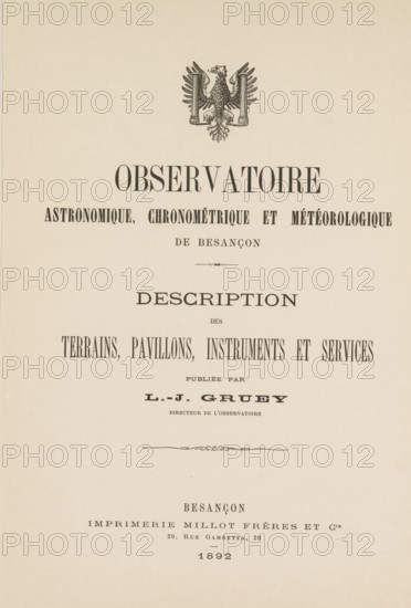 Astronomy observation, chronometry and météorologique de Besançon description of the terrains, pavillons, instruments and services, book, printer (person): Imprimerie Millot Frères et Cie, Besançon, publisher: Louis Jules Gruey, 1892, printer (person), pasteboard, biological material, paper, leather, albumen print, printing, lithography, printing and albumen printing, height 323 mm x width 240 mm x thickness 24 mm, The image shows a vertically oriented page with an ornate emblem of an eagle near the top and centered typographic elements arranged below it; the page background is a light beige with slight paper texture and small aged spots, and decorative flourishes separate sections of large centered headings and narrower lines of printed content, all in dark ink.