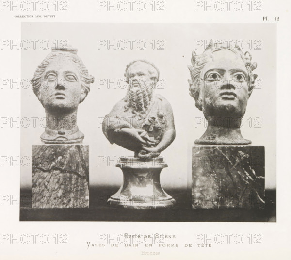 Bust of Silenus and two vases in the shape of a head, Buste de Silène Vases de bain en forme de tête, page, photomechanical print, number: 'Pl. 12', photographer: Stephane Geoffray, Paris, 1879, paper, collotype, photoprint, height 155 mm x width 200 mm, piece of sculpture, reproduction of a piece of sculpture, chest, bust - AA - female human figure, container of metal: bucket, can, canister, drum, tin, Three sculpted heads and an upper torso are shown mounted on pedestals. The left head has stylized hair pulled back with a flat element on top and a smooth neck rising from a marble pedestal. The central figure is a bearded torso with folded arms and a rounded base beneath it, the beard rendered in textured, curled strands. The right head has wide eyes, small horn-like projections on the hairline, and a similar marble pedestal beneath the neck. The background is light and plain, and the overall image is monochrome with varied stone and marble textures.