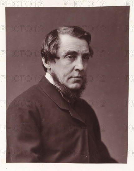 Portrait of an unknown man, photograph, page, photographer: Ernest Edwards, London, c. 1859 - in or before 1869, paper, carbon print, photographie de charbon, height 171 mm x width 134 mm, historical persons not known by name, A sepia-toned portrait of a middle-aged man shown from the shoulders up in a three-quarter view, with neatly combed hair that parts to the side and longer sideburns that extend into a trimmed beard along his jaw, wearing a dark jacket and a visible collar, his expression neutral with slightly downcast eyes, against a plain, darker background and a lighter border around the image.