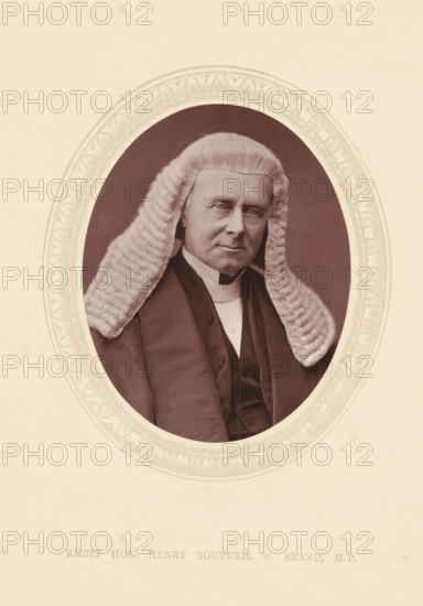 Right hon. Henry Bouverie W. Brand MP, page, photomechanical print, photographer: Lock & Whitfield, cliché maker: anonymous, c. 1871 - in or before 1876, paper, Woodburytype, height 115 mm x width 89 mm, Person, Henry Brand, politician, eg party leader, historical persons (portraits and scenes from the life) ((full) bust portrait), An oval-framed sepia portrait of an older person wearing a full white curled wig and dark formal robes, the face showing a neutral expression and visible facial lines, the wig’s textured curls falling over the shoulders, the dark coat and vest visible beneath a high white collar, the ornate oval border surrounding the portrait set against a pale background.