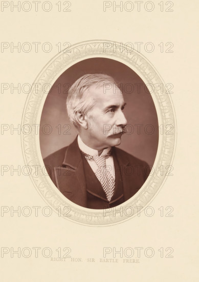 Right. hon. Sir Bartle Frere, page, photomechanical print, photographer: Lock & Whitfield, cliché maker: anonymous, c. 1871 - in or before 1876, paper, Woodburytype, height 115 mm x width 89 mm, Person, Henry Bartle Frere, colonial governor, historical persons (portraits and scenes from the life) ((full) bust portrait), An oval portrait of an older man in profile facing right, set against a plain vignette background and surrounded by an ornate decorative oval border, showing his light hair combed back, a prominent mustache, a high-collared shirt with a patterned necktie, and a dark suit jacket with lapels.