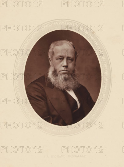 Sir Richard Baggallay, page, photomechanical print, photographer: Lock & Whitfield, cliché maker: anonymous, c. 1871 - in or before 1876, paper, Woodburytype, height 115 mm x width 89 mm, Person, Richard Baggallay, magistracy, judges, historical persons (portraits and scenes from the life) ((full) bust portrait), A sepia-toned oval portrait of a seated man with a full beard and moustache, wearing a dark suit jacket and a light-colored shirt with a vest, set against a plain dark background and framed by an ornate decorative oval border on a light paper background.