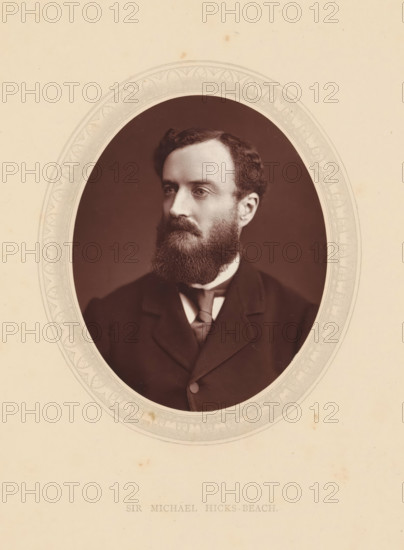 Sir Michael Hicks-Beach, page, photomechanical print, photographer: Lock & Whitfield, cliché maker: anonymous, c. 1871 - in or before 1876, paper, Woodburytype, height 115 mm x width 89 mm, Person, Michael Edward Hicks Beach, politician, eg party leader, historical persons (portraits and scenes from the life) ((full) bust portrait), An oval sepia photograph of a man with dark hair and a full beard set against a dark background, framed by an ornate pale border on a light cream sheet, showing the man in a dark suit jacket with a high collar and a necktie, his gaze directed slightly to one side.