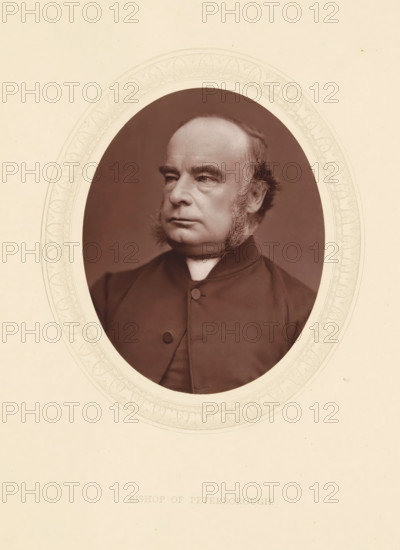 Bishop of Peterborough, page, photomechanical print, photographer: Lock & Whitfield, cliché maker: anonymous, c. 1871 - in or before 1876, paper, Woodburytype, Woodbury Process, height 115 mm x width 89 mm, Person, William Magee, officer, historical persons (portraits and scenes from the life) ((full) bust portrait), An oval portrait of an older man with a high forehead and receding hairline, sideburns extending down his cheeks, and a solemn expression, shown from the chest up wearing a dark buttoned clerical garment with a white collar, set against a plain dark background and framed by an ornate light-colored oval mat on a light paper.