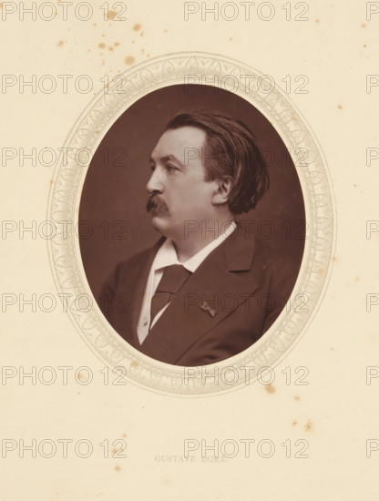 Gustave Doré, page, photomechanical print, photographer: Lock & Whitfield, cliché maker: anonymous, c. 1871 - in or before 1876, paper, Woodburytype, Woodbury Process, height 115 mm x width 89 mm, Person, graphic artist, historical persons (portraits and scenes from the life) ((full) bust portrait), An oval sepia portrait of a man in profile set within an ornate decorative oval frame on a cream paper background, showing the man's dark hair combed back, a thick mustache, a collared shirt with a tie and a dark jacket, with some scattered small brown spots and stains on the surrounding paper.