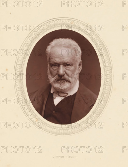 Victor Hugo, page, photomechanical print, photographer: Étienne Carjat, Paris, cliché maker: anonymous, c. 1871 - in or before 1876, paper, Woodburytype, Woodbury Process, height 115 mm x width 89 mm, Person, portrait of a writer, historical persons (portraits and scenes from the life) ((full) bust portrait), A sepia-toned oval portrait of an older man with light hair and a full beard and mustache, wearing a dark jacket and a light-colored shirt with a tied neck cloth, set against a dark background and surrounded by an ornate decorative oval border on a pale paper background.