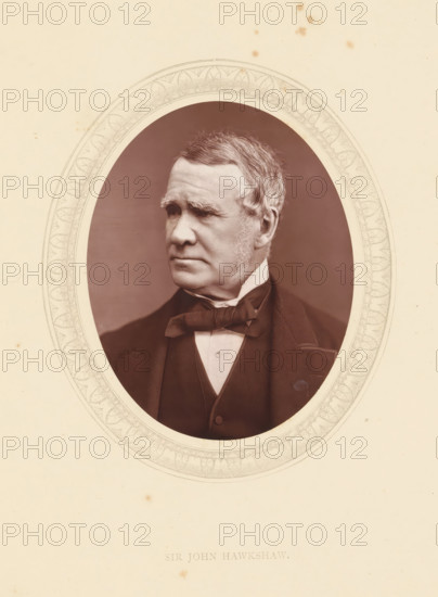 Sir John Hawkshaw, page, photomechanical print, photographer: Lock & Whitfield, cliché maker: anonymous, c. 1871 - in or before 1876, paper, Woodburytype, Woodbury Process, height 115 mm x width 89 mm, Person, John Hawkshaw, engineering, historical persons (portraits and scenes from the life) ((full) bust portrait), An oval portrait of an older man shown from the chest up, set within an ornate circular frame on a pale background; the man faces slightly to his left and has short, neatly combed hair with sideburns, a high forehead, and a serious expression, wearing a dark jacket, waistcoat, white shirt, and a bow tie.