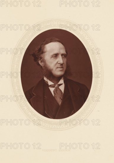 Viscount Sandon, page, photomechanical print, photographer: Lock & Whitfield, cliché maker: anonymous, c. 1873 - in or before 1878, paper, Woodburytype, Woodbury Process, height 115 mm x width 89 mm, Person, Dudley Ryder, politician, eg party leader, historical persons (portraits and scenes from the life) ((full) bust portrait), An oval-framed sepia portrait of a man shown from the chest up, facing slightly to his left, with wavy hair combed back and prominent sideburns extending along his jaw; he wears a dark jacket with wide lapels, a waistcoat, a high-collared shirt, and a patterned cravat tied at the neck, all set against a plain dark background and surrounded by a pale decorative oval border on a light background.