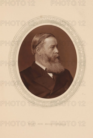 Right hon. Hugh Childers, page, photomechanical print, photographer: Lock & Whitfield, cliché maker: anonymous, c. 1873 - in or before 1878, paper, Woodburytype, Woodbury Process, height 115 mm x width 89 mm, Person, Hugh Childers, politician, eg party leader, historical persons (portraits and scenes from the life) ((full) bust portrait), A sepia-toned oval portrait set against a light background shows a man in three-quarter profile facing right with neatly combed hair and a full beard and mustache, wearing a dark formal jacket and a white shirt visible at the collar, the oval is surrounded by a decorative patterned border.