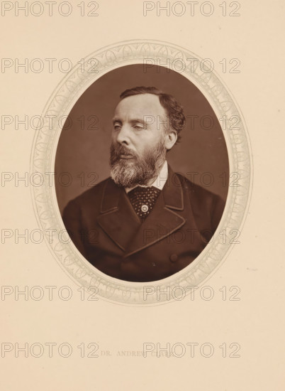 Dr. Andrew Clark, page, photomechanical print, photographer: Lock & Whitfield, cliché maker: anonymous, c. 1873 - in or before 1878, paper, Woodburytype, Woodbury Process, height 115 mm x width 89 mm, Person, Andrew Clark, physician, doctor, historical persons (portraits and scenes from the life) ((full) bust portrait), An oval photographic portrait of a middle-aged man with a full beard and mustache, short hair combed to the side, and a neutral expression, shown from the chest up and turned slightly to his left, set against a plain dark background and surrounded by an ornate decorative oval border on a light-colored mat.
