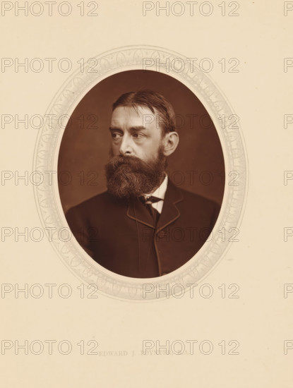 Edward J. Poynter, RA, page, photomechanical print, photographer: Lock & Whitfield, cliché maker: anonymous, c. 1875 - in or before 1880, paper, Woodburytype, Woodbury Process, height 115 mm x width 89 mm, Person, Edward John Poynter (Sir), portrait, self-portrait of painter, historical persons (portraits and scenes from the life) ((full) bust portrait), A sepia portrait of a bearded man shown from the chest up inside an ornate oval frame, the man facing slightly to his left with a full dark beard and mustache, short combed hair, a high-collared shirt, and a dark jacket with visible lapel and button detail, the framed oval set against a pale background.