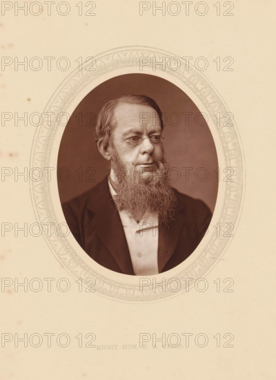 Right hon. RA Cross, page, photomechanical print, photographer: Lock & Whitfield, cliché maker: anonymous, c. 1875 - in or before 1880, paper, Woodburytype, height 115 mm x width 89 mm, Person, Richard Assheton Cross, politician, eg party leader, historical persons (portraits and scenes from the life) ((full) bust portrait), A sepia-toned oval portrait of a middle-aged man with neatly combed hair and a long, full beard, wearing small round eyeglasses and a dark jacket over a light shirt, set against a plain dark background and surrounded by a decorative oval border on a light, slightly aged paper.