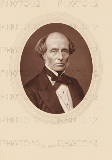 Sir Henry Manisty, page, photomechanical print, photographer: Lock & Whitfield, cliché maker: anonymous, c. 1875 - in or before 1880, paper, Woodburytype, Woodbury Process, height 115 mm x width 89 mm, Person, Henry Manisty, magistracy, judges, historical persons (portraits and scenes from the life) ((full) bust portrait), A sepia-toned oval portrait of an older man with a high forehead and receding hairline, flanked by short wavy hair and sideburns, wearing a dark formal jacket with wide lapels, a white shirt with a high collar, and a dark bow tied at the neck, set against a plain dark background and surrounded by a decorative oval border on a light paper background.
