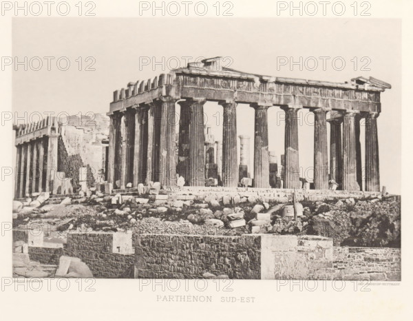Parthenon on the Acropolis of Athens, Parthénon sud-est, page, photomechanical print, Athens, cliché maker: Dujardin, printer (person): Chardon-Wittmann, c. 1880 - in or before 1890, photographer, printer (person), Athene, Periféreia Protevoúsis, paper, photoaquatint, height 145 mm x width 215 mm, ruin of a building, architecture, temple, shrine, Greek religion, Acropolis, Parthenon, A sepia-toned photograph of an ancient stone temple with a row of tall fluted columns supporting a heavy entablature and partial pediments, set on a raised platform scattered with broken stone blocks and rubble; the foreground shows layered stone retaining walls and more scattered masonry, while additional ruined walls and architectural fragments appear behind and to the left of the main structure against a pale sky.