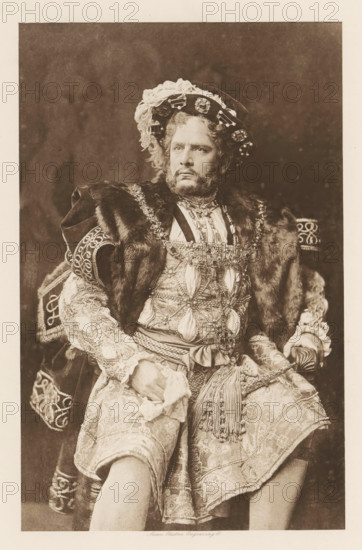 William Terriss (Henry VIII), page, photomechanical print, cliché maker: Swan Electric Engraving Co., c. 1880 - in or before 1890, photographer, paper, photoaquatint, height 211 mm x width 131 mm, Person, portrait of actor, actress, A seated man wearing an ornate costume with heavy embroidery, beading, and layered fabrics is shown from head to knees. He has a wreathlike hat decorated with lace and jewels, curly hair, and a full beard and mustache. A fur-trimmed cloak drapes over his shoulders and a richly decorated tunic with patterned sleeves and a sash with tassels covers his torso and hips. His hands rest on his lap, one holding a cloth, and he wears patterned knee breeches. The background is plain and dark.