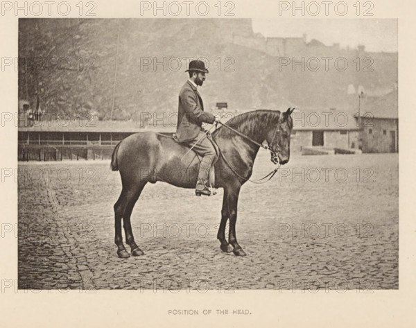 Position of the head, Man on a horse, page, photomechanical print, photographer: Alexander Nicol (possibly), Edinburgh (possibly), cliché maker: Römmler & Jonas, Dresden, c. 1879 - in or before 1889, paper, collotype, photoprint, height 98 mm x width 137 mm, horse, riding a horse, ass, or mule, rider, horseman, head-gear: bowler hat, A sepia-toned photograph showing a man seated on a horse in profile facing right, the man wearing a dark bowler hat and a suit with trousers and boots, holding the reins with both hands; the horse has a bridle and a short docked tail and stands on a cobbled surface, with a low building and a row of fencing visible in the background and a hazy hillside rising behind them.