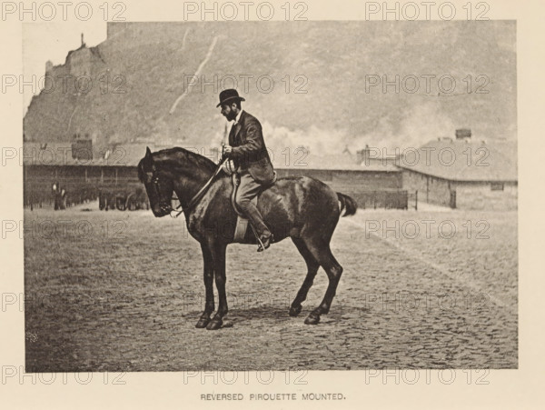 Man on horseback, Reversed pirouette mounted, page, photomechanical print, photographer: Alexander Nicol (possibly), Edinburgh (possibly), cliché maker: Römmler & Jonas, Dresden, c. 1879 - in or before 1889, paper, collotype, photoprint, height 97 mm x width 137 mm, horse, riding a horse, ass, or mule, rider, horseman, head-gear: bowler hat, A sepia-toned scene shows a man wearing a dark suit and bowler hat seated on a dark horse in a cobblestone open area, the man holding reins and looking downward; behind them are low buildings with pitched roofs and chimneys, and in the distant background a rocky hillside rises with a structure silhouetted near its top.