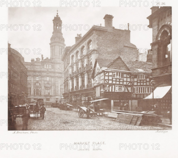 Market Place, looking south, View of Market Place in Manchester with a view of the tower of the Royal Exchange, page, photomechanical print, number: 'Pl. 36.', photographer: Brothers, Alfred, Manchester, cliché maker: anonymous, c. 1868 - in or before 1878, printer (person), paper, collotype, photoprint, height 138 mm x width 185 mm, market, hand-cart, tower, clock tower, monumental adornment, A sepia-toned street scene showing a cobbled road flanked by multi-story buildings of differing styles, including a timber-framed structure with visible exposed beams and small windows, and larger stone buildings with arched windows and decorative façades; a tall domed tower rises in the background with a lantern-like top, and a large brick chimney is visible atop one building; horse-drawn carts and a few people stand or walk along the street near wooden market stalls and piled planks; awnings extend over shopfronts and a projecting lamp hangs from one building; the sky appears pale and overcast.