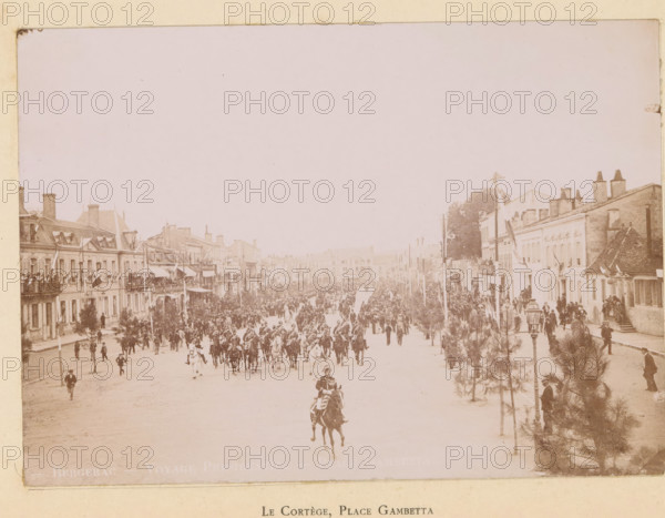 Le cortège, Place Gambetta, Bergerac- Voyage presidentiel- Place Gambetta, View of the entry of President Félix Faure on the Place Gambetta in Bergerac, photograph, page, Bergerac, 1895-06-04, photographer, paper, daylight gelatin silver print, height 118 mm x width 167 mm, riding a horse, ass, or mule, rider, horseman, square, circus, triumphal entry and public reception, pageant, 'entrée solennelle', 'joyeuse entrée', façade (of house or building), A wide street scene with rows of multi-story buildings on both sides and crowds filling the roadway and sidewalks; many people stand on balconies and at windows while a large mounted procession of riders moves down the center of the street, visible horses and riders at the front and more figures following; trees and lamp posts line the sidewalks, and decorative flags or banners hang from some buildings and poles; architectural details of the buildings include chimneys, pitched roofs, and rows of windows, and clusters of people gather near ...