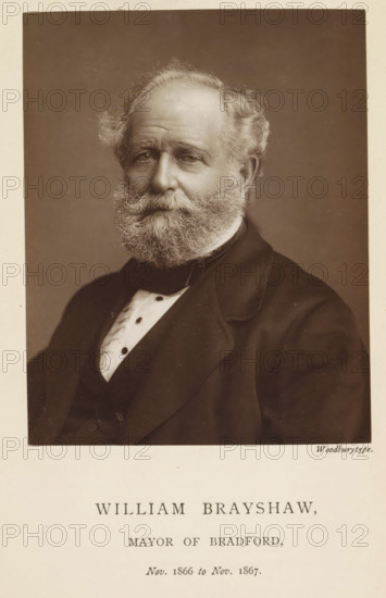 Portrait of William Brayshaw, William Brayshaw, mayor of Bradford, page, photomechanical print, inscription: 'Nov. 1866 to Nov. 1867.', photographer: Appleton & Co., Bradford (England), cliché maker: anonymous, c. 1871 - in or before 1881, paper, Woodburytype, Woodburytypepie, height 116 mm x width 92 mm, historical persons (portraits and scenes from the life) ((full) bust portrait), A sepia portrait of an older man shown from the chest up, facing slightly toward the camera with a neutral expression, a full beard and mustache, thinning hair at the crown and fuller hair at the sides, wearing a dark suit jacket over a waistcoat and a light-colored shirt with a high collar and visible buttons, set against a plain, softly shaded background and framed by a light border.