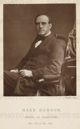 Portrait of Mark Dawson, Mark Dawson, mayor of Bradford, page, photomechanical print, inscription: 'Nov. 1869 to Nov. 1871.', photographer: Appleton & Co., Bradford (England), cliché maker: anonymous, c. 1871 - in or before 1881, paper, Woodburytype, Woodburytypepie, height 116 mm x width 91 mm, historical persons (portraits and scenes from the life) ((full) bust portrait), A sepia portrait of a seated man wearing a dark double-breasted coat and a bow tie, with sideburns and hair combed back, sitting in an ornate upholstered chair with carved wooden armrests and patterned fabric; his hands rest in his lap and he looks toward the camera against a plain dark background.