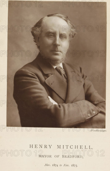 Portrait of Henry Mitchell, Henry Mitchell, mayor of Bradford, page, photomechanical print, inscription: 'Nov. 1874 to Nov. 1875.', photographer: Appleton & Co., Bradford (England), cliché maker: anonymous, c. 1871 - in or before 1881, paper, Woodburytype, height 116 mm x width 91 mm, Person, historical persons (portraits and scenes from the life) ((full) bust portrait), A sepia portrait of a middle-aged man shown from the waist up with arms crossed, wearing a suit jacket, waistcoat, and patterned tie, with sideburns and a trimmed beard, light-colored hair combed back, a neutral facial expression, and a plain softly shaded background.