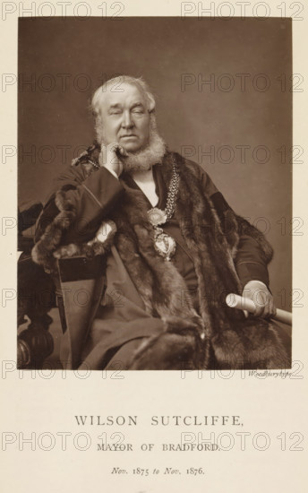 Portrait of Wilson Sutcliffe, Wilson Sutcliffe, mayor of Bradford, page, photomechanical print, inscription: 'Nov. 1875 to Nov. 1876.', photographer: Appleton & Co., Bradford (England), cliché maker: anonymous, c. 1871 - in or before 1881, paper, Woodburytype, height 116 mm x width 91 mm, historical persons (portraits and scenes from the life), A sepia portrait of an older man seated and facing forward, wearing a dark formal robe trimmed with fur and a heavy decorative chain with a large medallion visible on his chest, his left hand resting on his cheek and his right hand holding a cylindrical object, he has a full beard and short hair, and there is a plain neutral backdrop behind him.